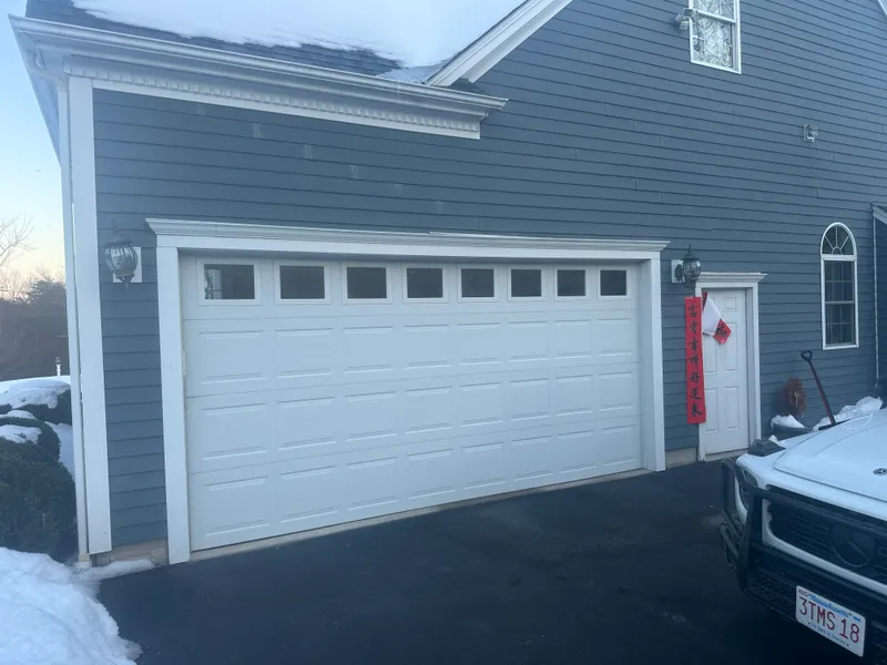 Blue-gray colonial with a two-car garage, seen from the side